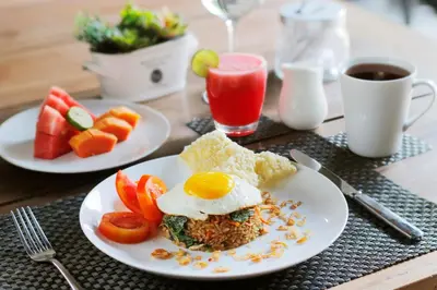 a table with two plates of food with eggs and fruit at Villa Suku Berawa in Canggu