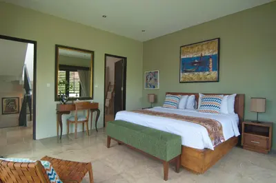 a bedroom with a large bed and a table at Villa Uma Sari - 2BDR, Private Pool and Sunset Rooftop, Quiet and Central in Seminyak