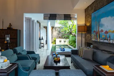 a living room with blue couches and a table at Mosan House - unique art-filled gem in perfect location a short walk from the beach or Seminyak Square including AC office for remote working in Seminyak
