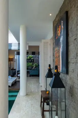 a living room with a stone wall at Mosan House - unique art-filled gem in perfect location a short walk from the beach or Seminyak Square including AC office for remote working in Seminyak