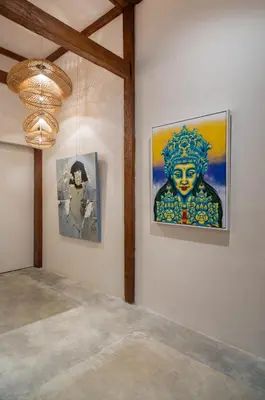 a room with paintings on the wall and a chandelier at Blue Karma Village in Seminyak