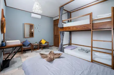 a bedroom with a bunk bed with a desk and a desk at Interconnection Hostel in Kuta