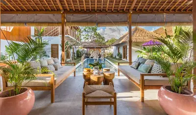 an outdoor patio with couches and plants and a pool at Villa HOI by Alfred in Bali in Seminyak