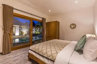 a bedroom with a bed and a large window at Villa HOI by Alfred in Bali in Seminyak