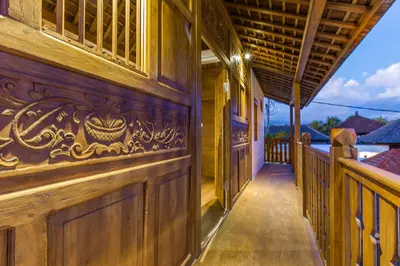 a wooden house with a hallway leading to a porch at Villa HOI by Alfred in Bali in Seminyak