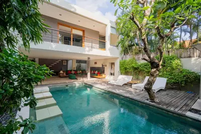 a villa with a swimming pool and a house at VILLA OLYMPIA in Seminyak