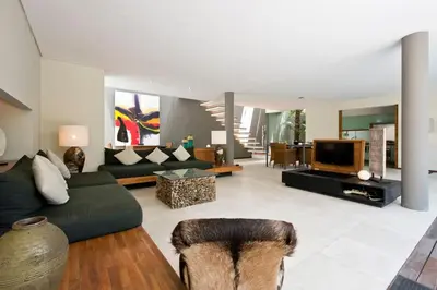 a living room with a couch and a tv at VILLA OLYMPIA in Seminyak