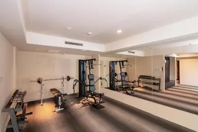 a gym with several treadmills and exercise equipment at Swiss-Belhotel Rainforest in Kuta