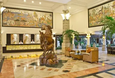 a lobby with a statue in the middle of a building at Bali Rani Hotel in Kuta