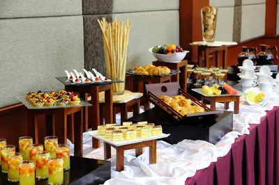 a buffet line with desserts and other food on tables at Bali Rani Hotel in Kuta
