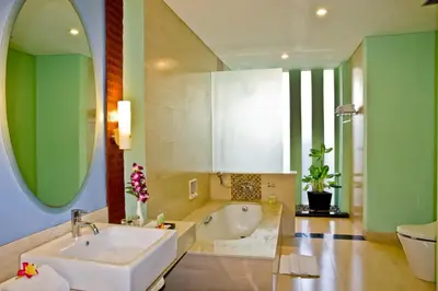 a bathroom with a white sink and a tub at The Rani Hotel & Spa in Kuta