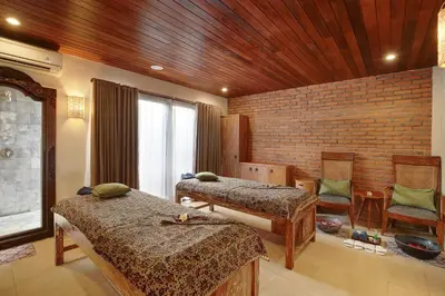 a room with two beds and a brick wall at Lumbini Luxury Villas and Spa in Jimbaran