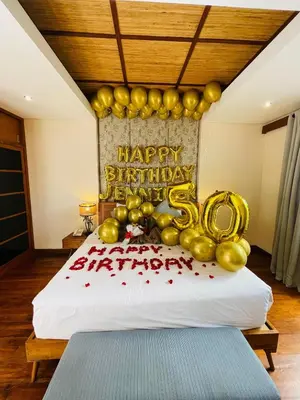 a bed with gold balloons and a happy anniversary cake at Beautiful Bali Villas - 6 mins walk to the beach in Legian