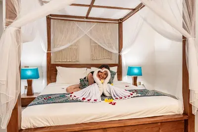 a woman laying on a bed with a teddy bear at Luxury - Villa K - Central Seminyak in Seminyak