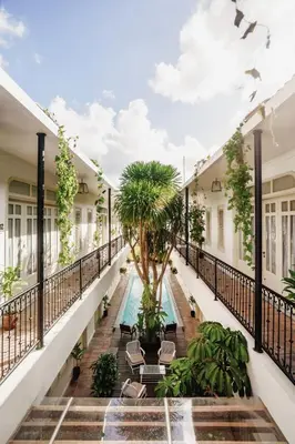 an indoor courtyard with a pool and palm trees at Brown Feather Batu Belig in Seminyak