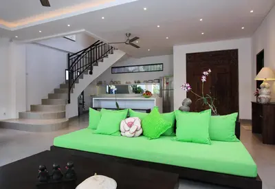 a large green bed in a room with stairs at Villa Jumah in Seminyak
