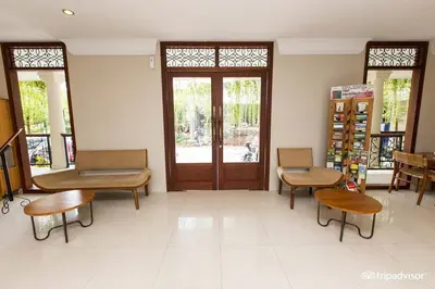 a waiting room with tables and chairs and a door at Seminyak Lagoon All Suites Hotel in Seminyak