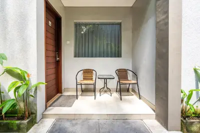 two chairs and a table on the porch of a house at Casa Dasa Legian in Seminyak