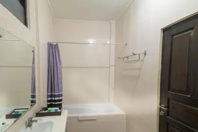 a white bathroom with a sink and a shower at Bali Sandy Resort in Kuta