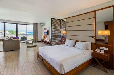 a bedroom with a large bed and a living room at Lv8 Resort Hotel in Canggu