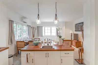 a kitchen with a sink and a living room at Umalas Suites in Seminyak