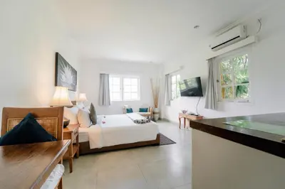 a bedroom with a bed and a living room at Umalas Suites in Seminyak