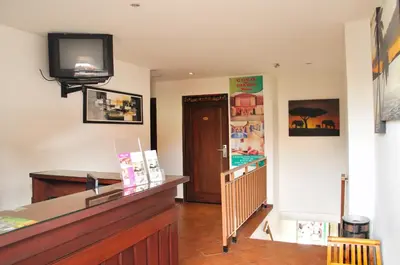 a room with a counter and a television on the wall at Bemo Corner Guest House in Kuta