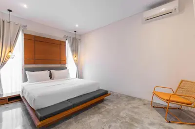 a bedroom with a bed and a chair in it at SooBali Niscala Villa 5 Bedroom in Canggu