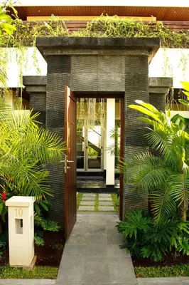 a entrance to a house with a wooden door at Sun Island Boutique Villas & Spa Seminyak in Seminyak