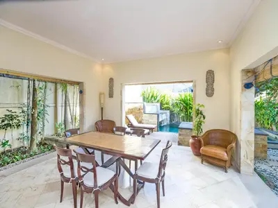 a dining room with a table and chairs at Villa Diana Bali in Legian