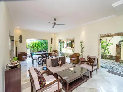a living room with a table and chairs at Villa Diana Bali in Legian