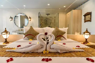 two swans made out of towels on a bed at Alindra Villas & Spa in Nusa Dua