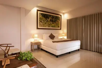 a bedroom with a bed and a painting on the wall at Alindra Villas & Spa in Nusa Dua