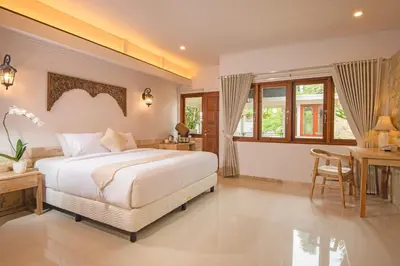 a bedroom with a large bed and a table and chairs at Alindra Villas & Spa in Nusa Dua