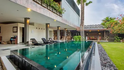 a swimming pool in front of a house at Alindra Villas & Spa in Nusa Dua