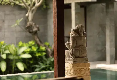 a statue of a woman sitting on a pole at Alindra Villas & Spa in Nusa Dua