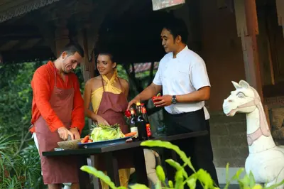 a group of people standing around a table with food and wine at Alindra Villas & Spa in Nusa Dua