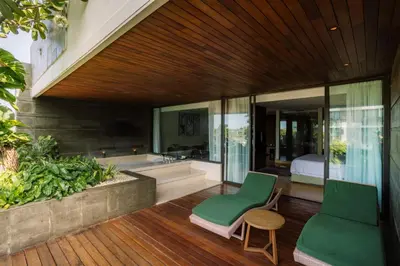 a room with a bedroom and a bed and a chair at Four Points by Sheraton Bali, Seminyak in Seminyak