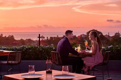 a man and woman sitting at a table with wine glasses at Four Points by Sheraton Bali, Seminyak in Seminyak