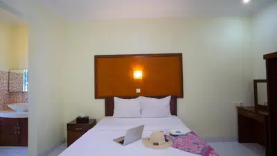 a bedroom with a bed with a hat on it at Teges Inn Kuta in Kuta