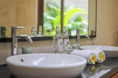 a bathroom with two sinks and two bottles of alcohol at Villa Harmony Canggu in Canggu