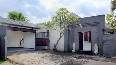 a white house with a tree in front of it at Villa Harmony Canggu in Canggu