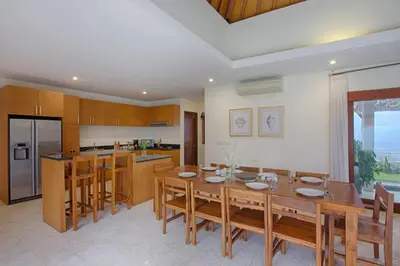 a kitchen with a wooden table and a dining room at Villa Harmony Canggu in Canggu
