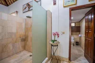 a bathroom with a walk in shower and a toilet at Nipper Villa - Spacious 4BR in Canggu in Canggu