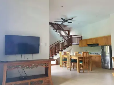 a living room with a television and a table with chairs at Villa Rahayu in Seminyak