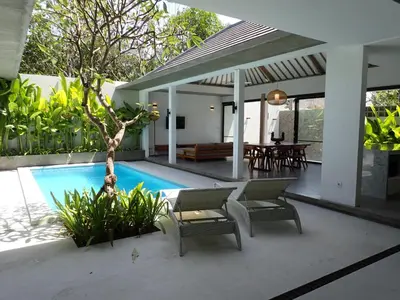 a villa with a swimming pool and a patio at Villa Hujan in Seminyak