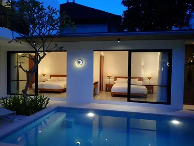 a villa with a swimming pool and a bedroom at Villa Hujan 2 in Seminyak