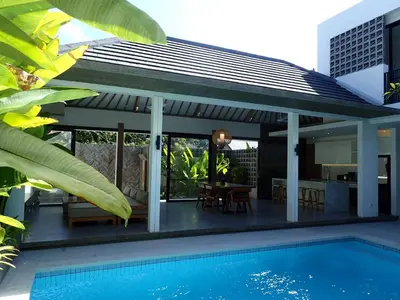 a villa with a swimming pool and a house at Villa Hujan 2 in Seminyak