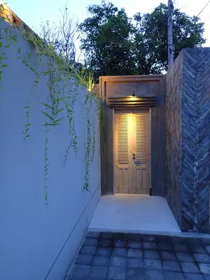 a wooden door with a light on top of it at Villa Hujan 2 in Seminyak