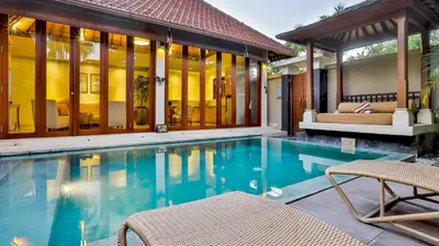 a pool with two chairs and a house at DISINI Luxury Spa Villas-CHSE Certified in Seminyak
